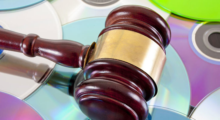 A wooden judge's gavel resting on a reflective surface.