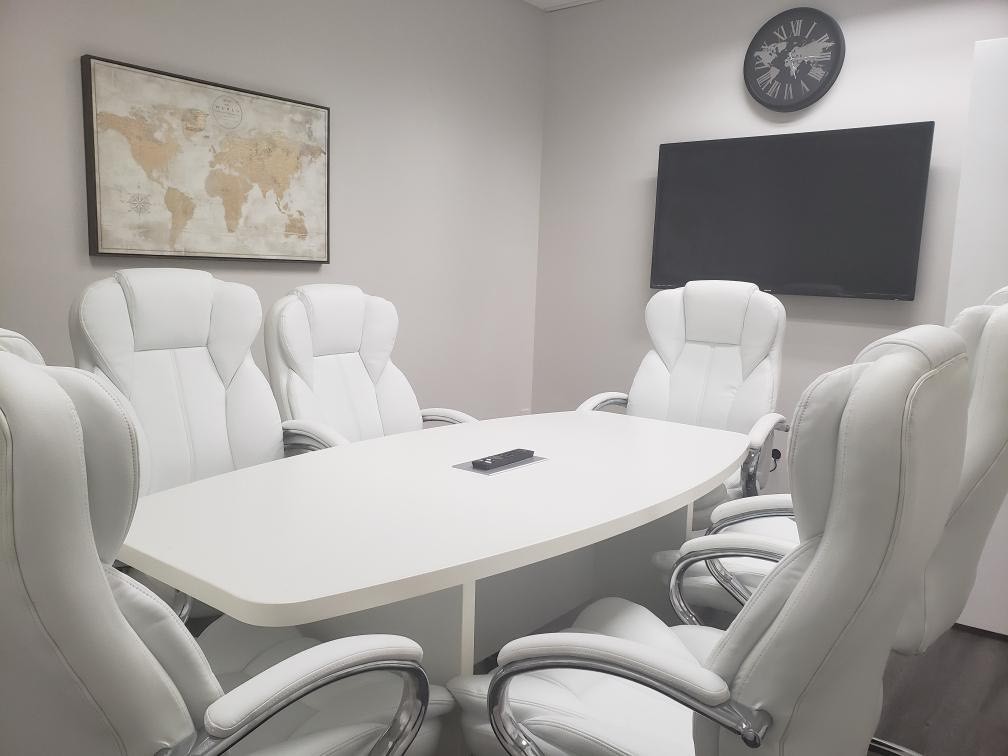 Modern conference room with white chairs.